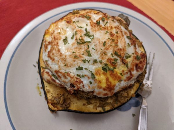 A roasted acorn squash stuffed with lentils and topped with an egg
